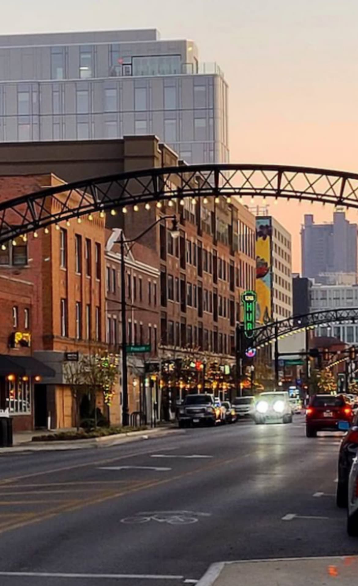 A lively urban street with historic buildings, warm lights, and a modern skyline at dusk. A lively urban street with historic buildings, warm lights, and a modern skyline at dusk.